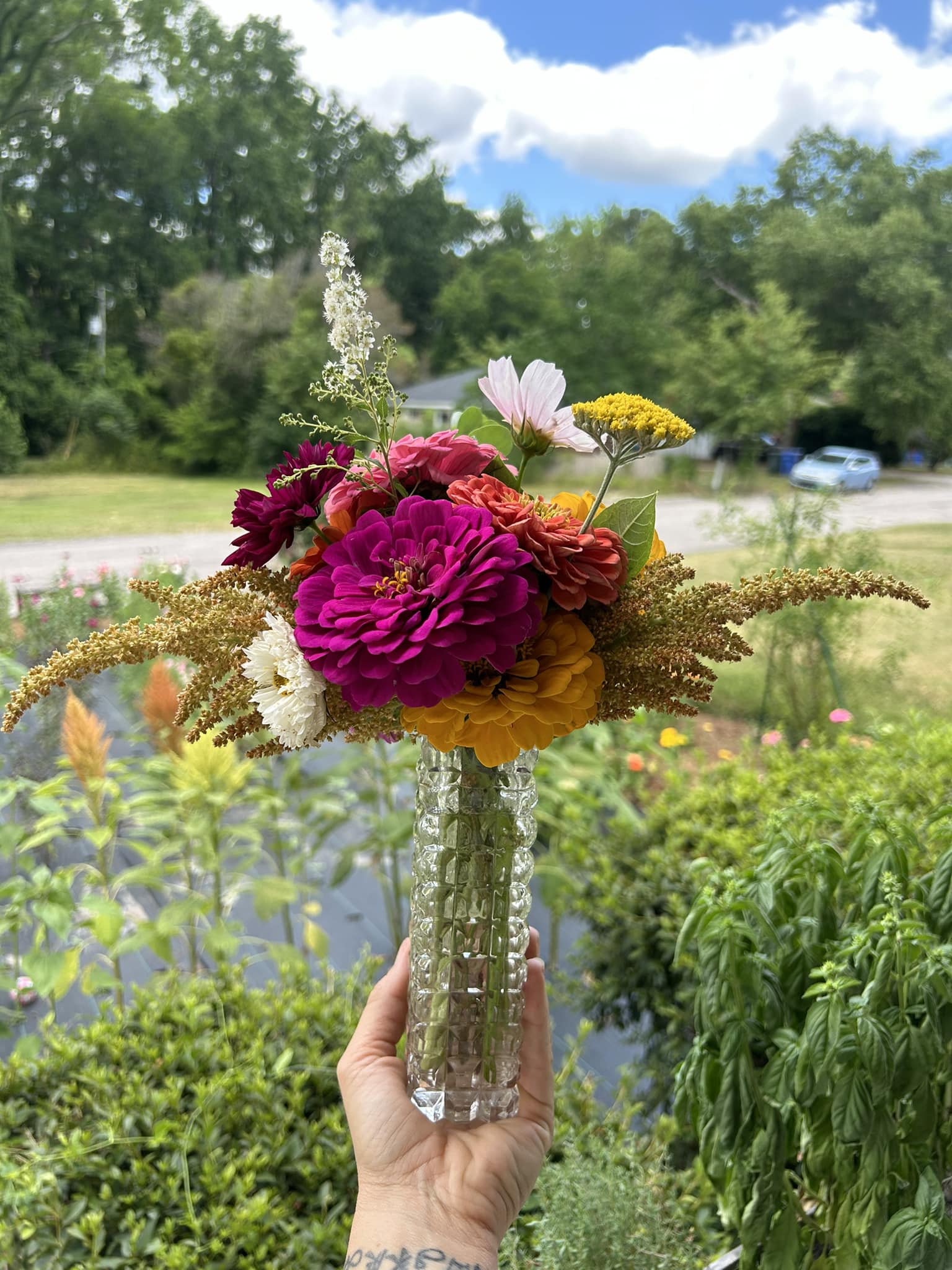 magenta zinnia and assorted flowers in a cut glass vase